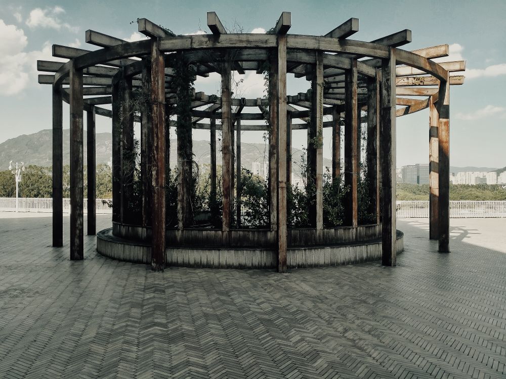 Pergola drewniana ze zintegrowaną ławką do wypoczynku w ogrodzie